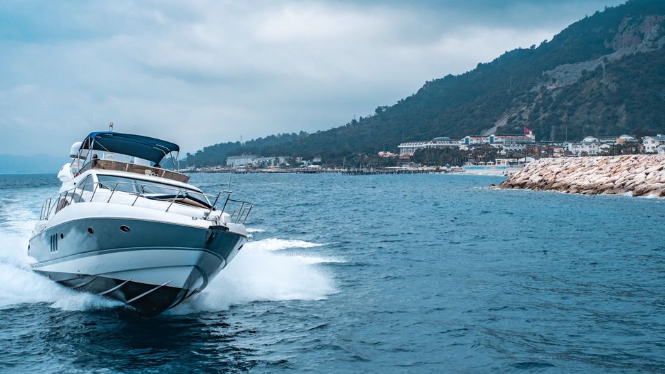 A motor boat gliding smoothly across the water, leaving a gentle wake behind it under a clear blue sky.