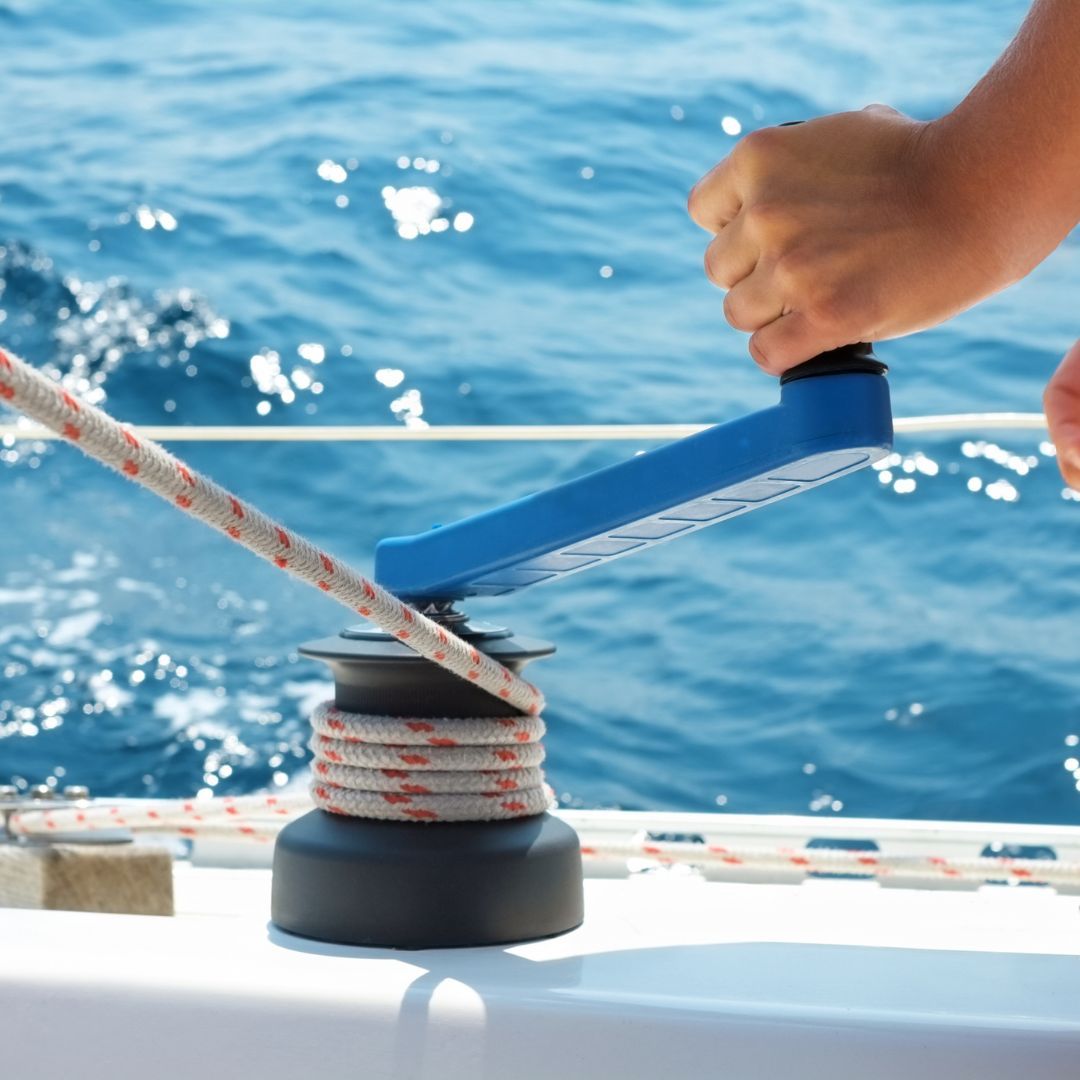 A person skillfully ties a sailboat using a rope, demonstrating nautical expertise and attention to detail.