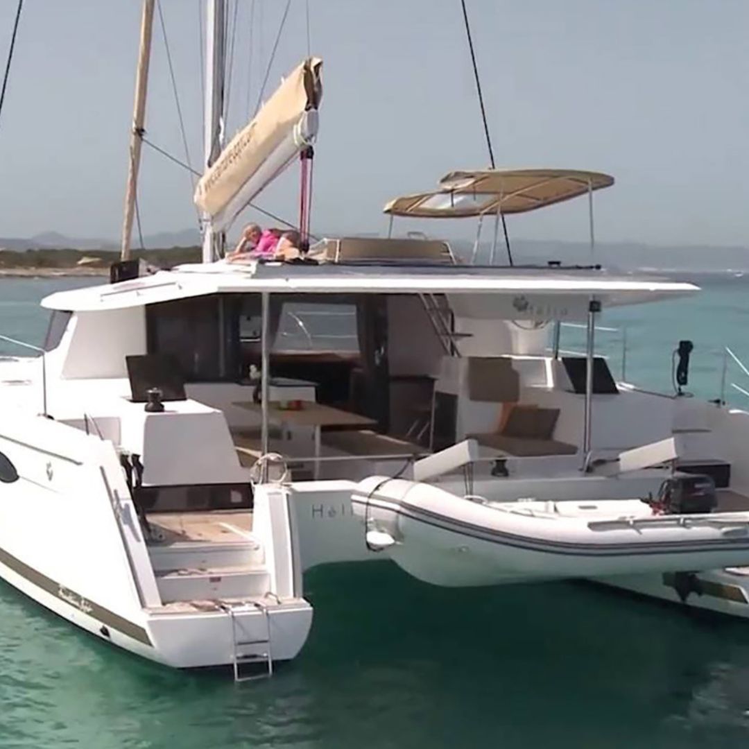 A spacious catamaran featuring a large deck, ideal for relaxation and enjoying the surrounding waters.
