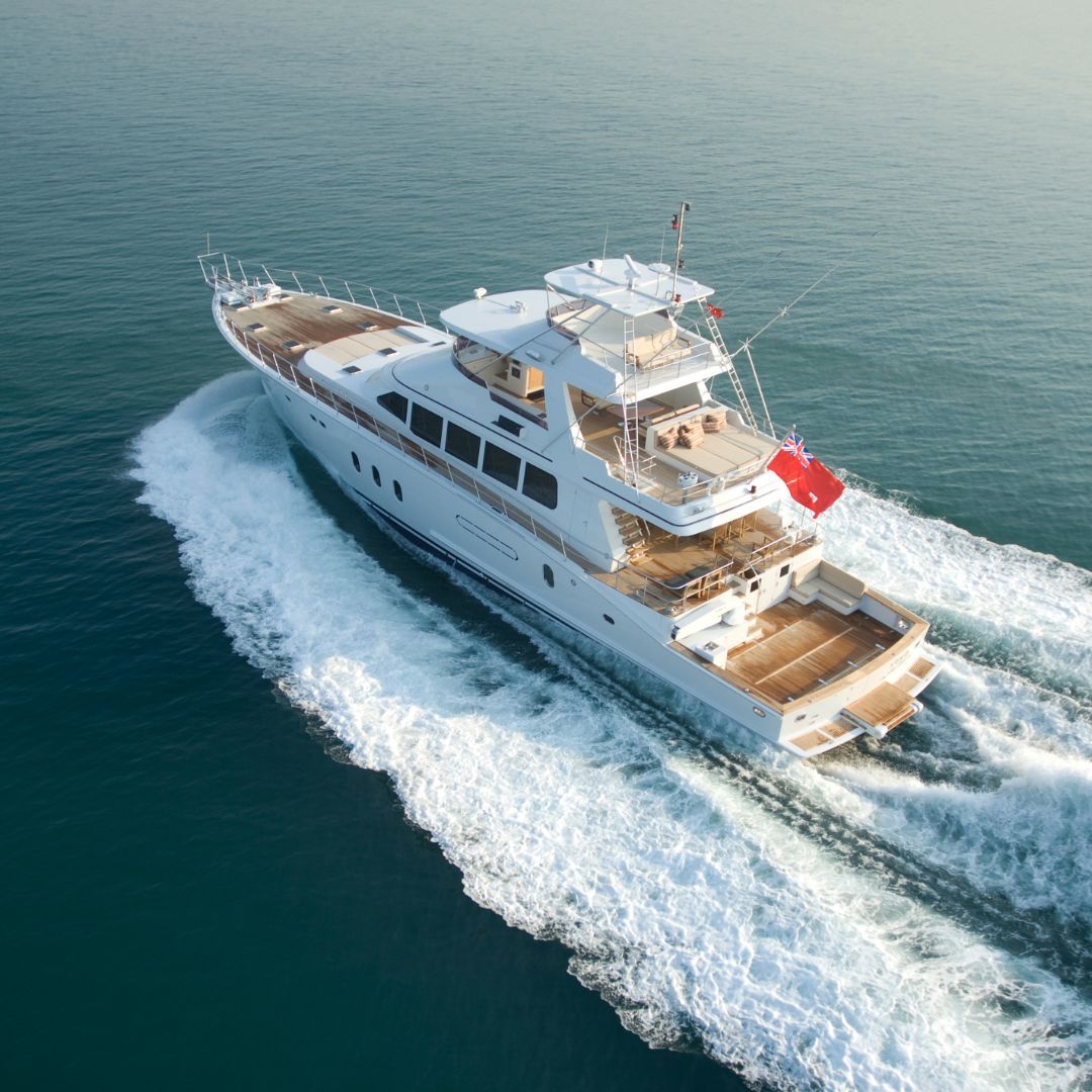 A white motorboat gliding smoothly across the water's surface under clear skies.