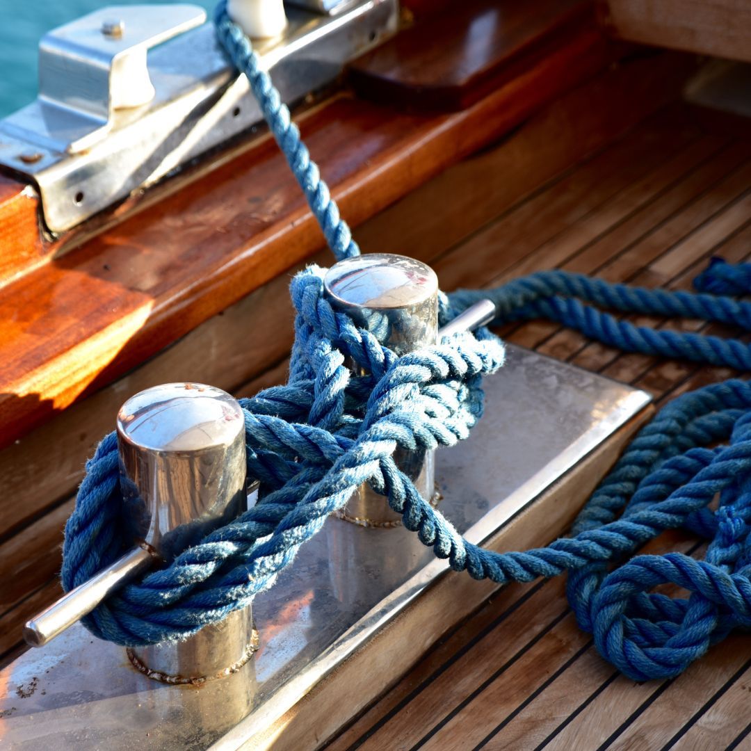 A close-up view of a rope coiled on a boat, showcasing its texture and details against the vessel's surface.
