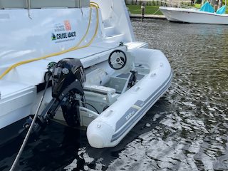 A motorized boat on a trailer, ready for transport, showcasing its sleek design and sturdy construction.
