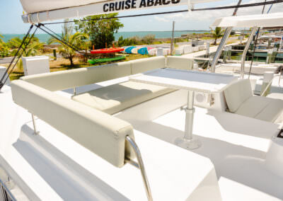 A catamaran deck featuring a table and chairs, ideal for relaxation and enjoying the surrounding views.