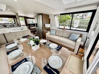 Elegant interior of a luxury yacht featuring a stylish dining table surrounded by plush chairs.