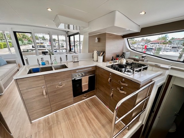 A cozy kitchen and living area on a boat, featuring modern appliances and comfortable seating with nautical decor.