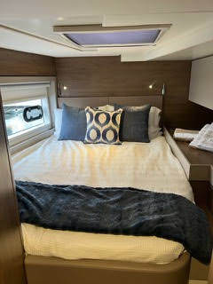 A luxurious master bedroom on a yacht featuring a spacious king-size bed, exuding elegance and comfort.