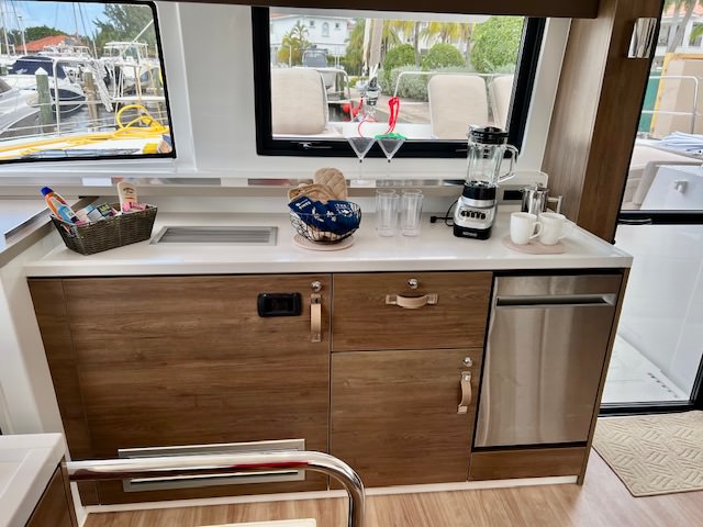 A compact kitchen on a boat featuring a sink and a refrigerator, showcasing nautical design and functionality.