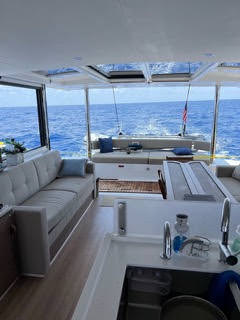 Interior view of a catamaran featuring a modern kitchen and a cozy living area, showcasing nautical design elements.