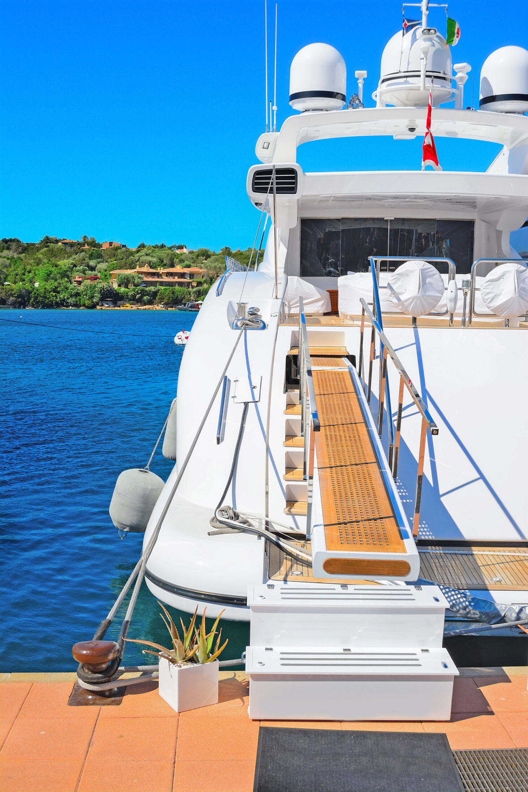 A white boat gently floats on calm water, reflecting the serene surroundings in a peaceful setting.
