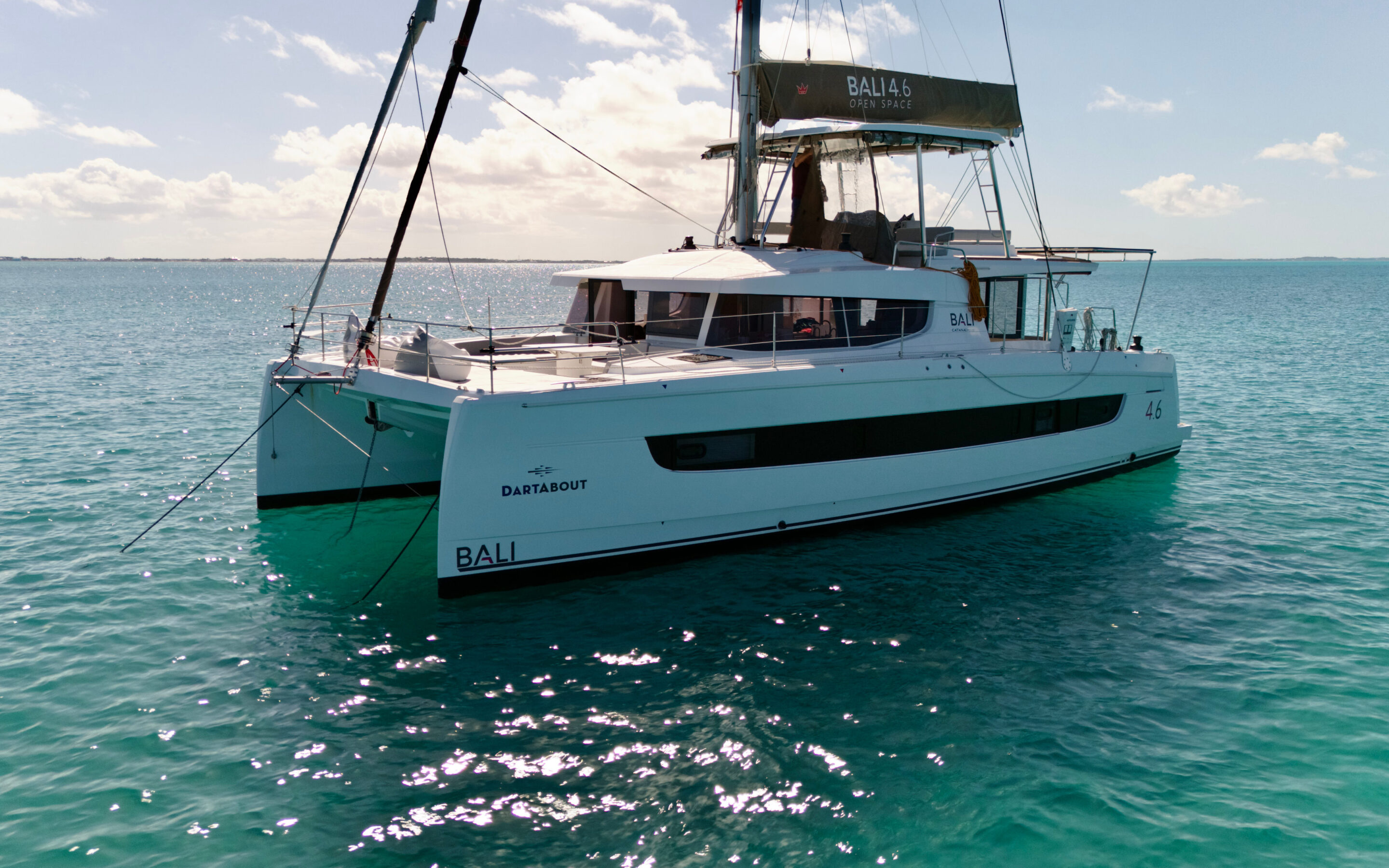 A catamaran anchored peacefully in the ocean, surrounded by calm waters and a clear blue sky.