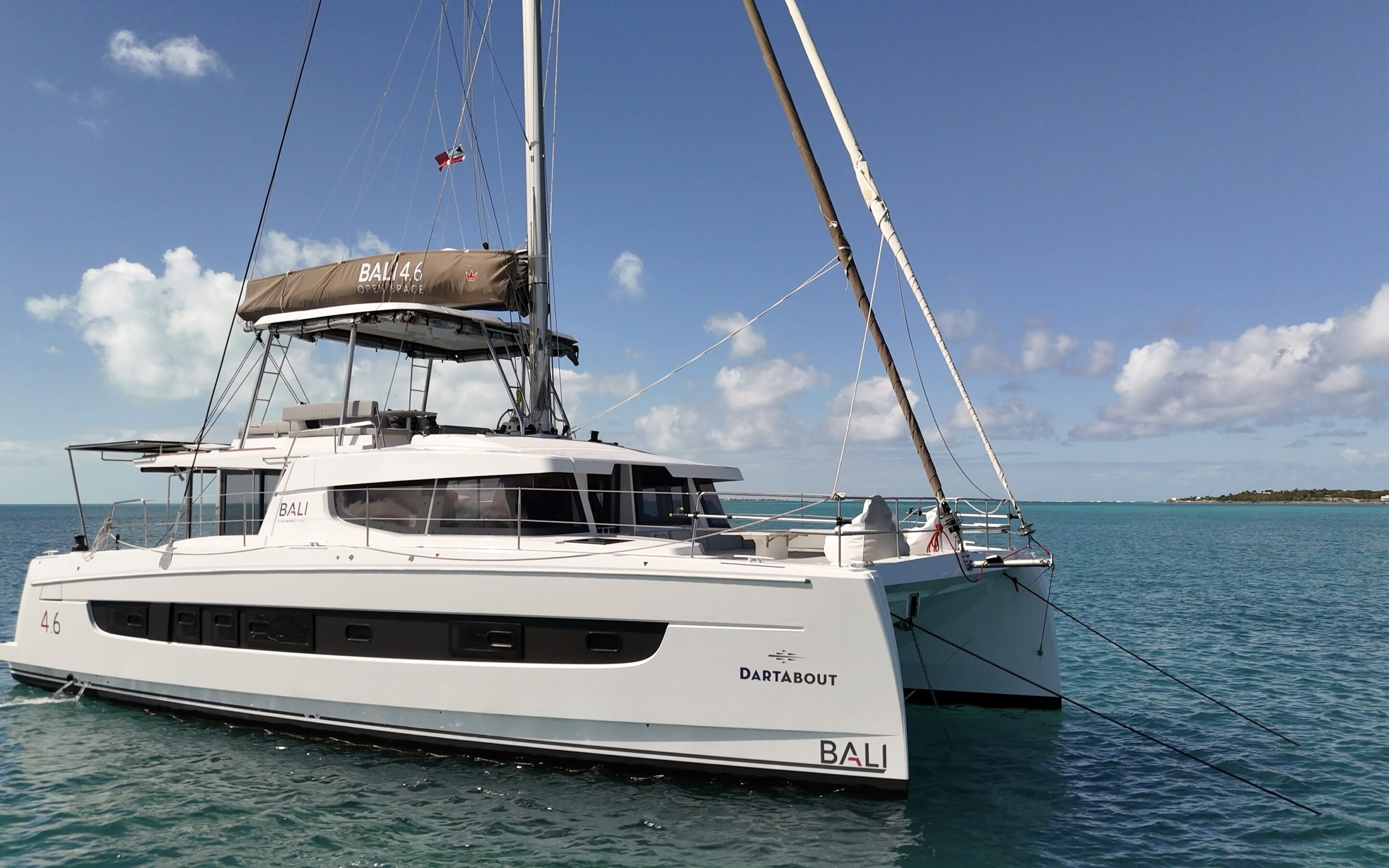 A catamaran anchored peacefully in the ocean, surrounded by calm waters and a clear blue sky.