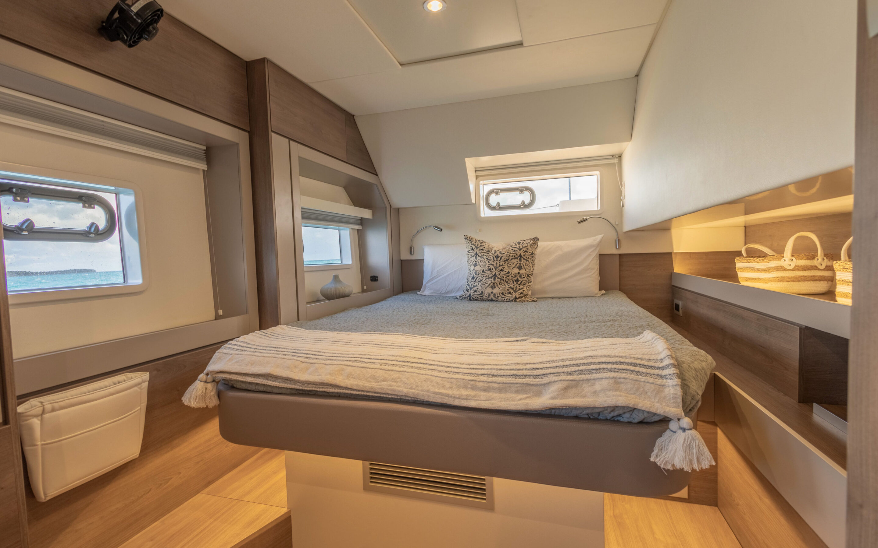Interior view of a boat featuring a cozy bed and a functional desk, showcasing a compact living space.