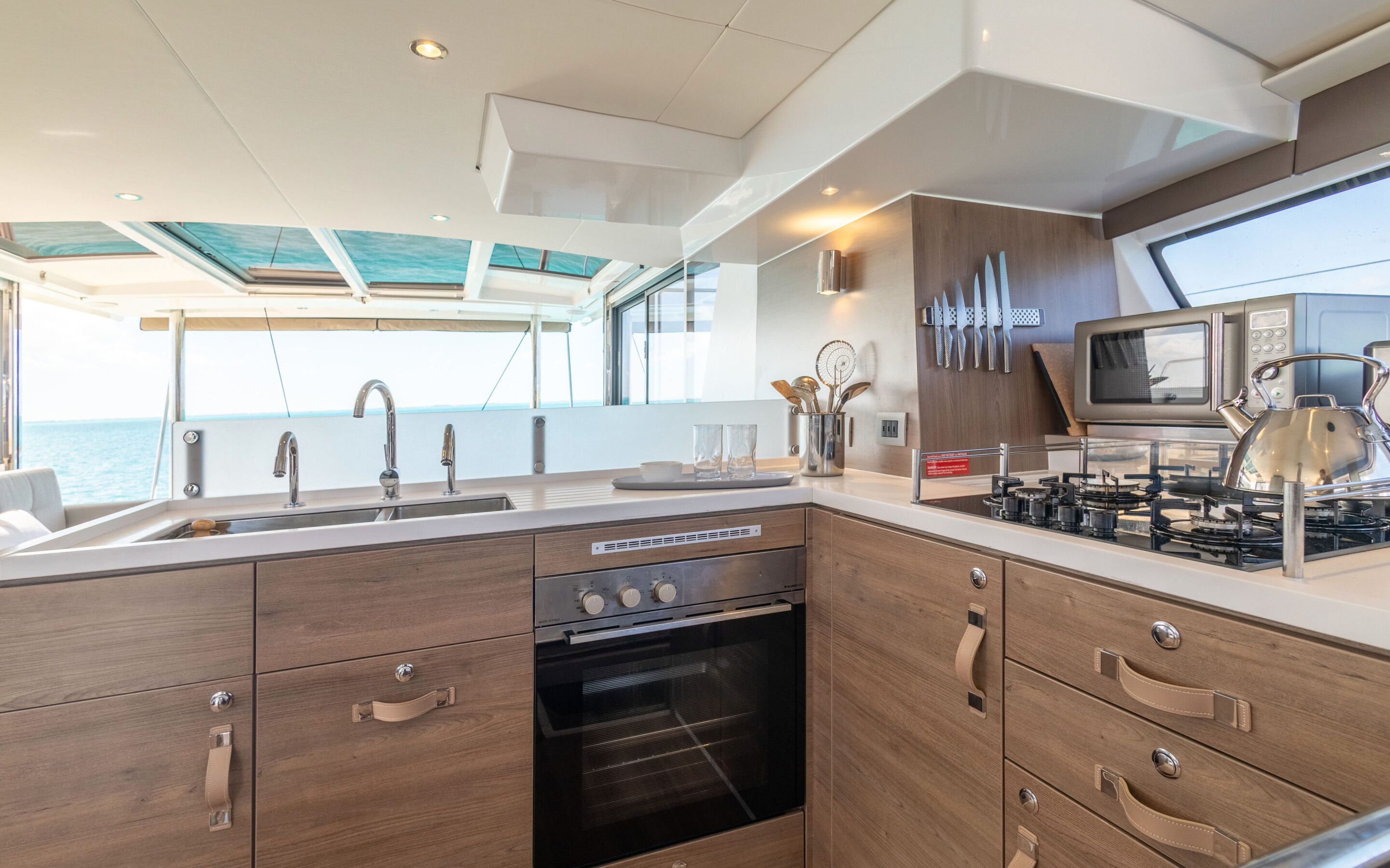 A boat's kitchen featuring a microwave oven, showcasing a compact and functional cooking space on the water.