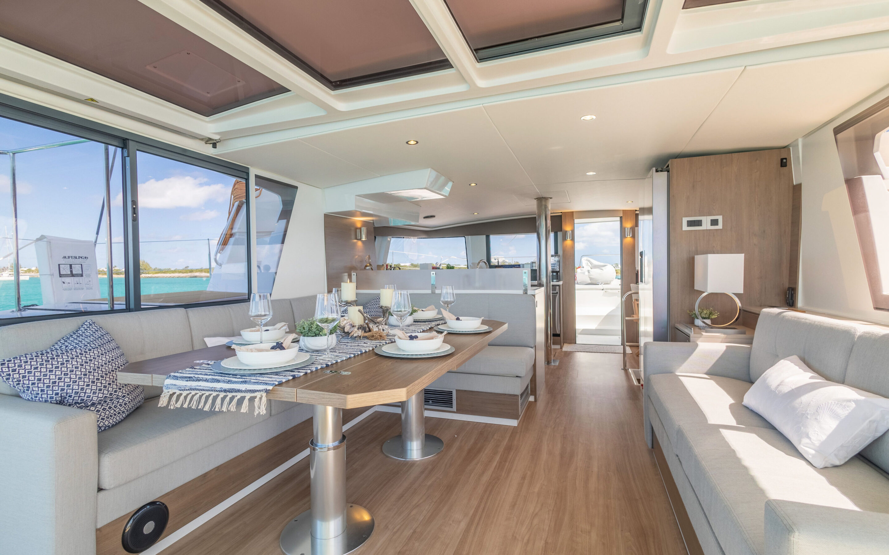 Interior view of a boat featuring a dining table surrounded by chairs, showcasing a cozy and inviting atmosphere.
