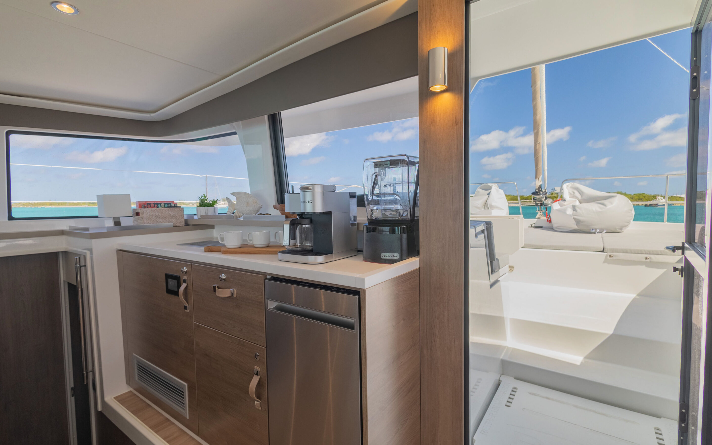 A boat's galley featuring a kitchen area and a scenic view of the ocean through the window.