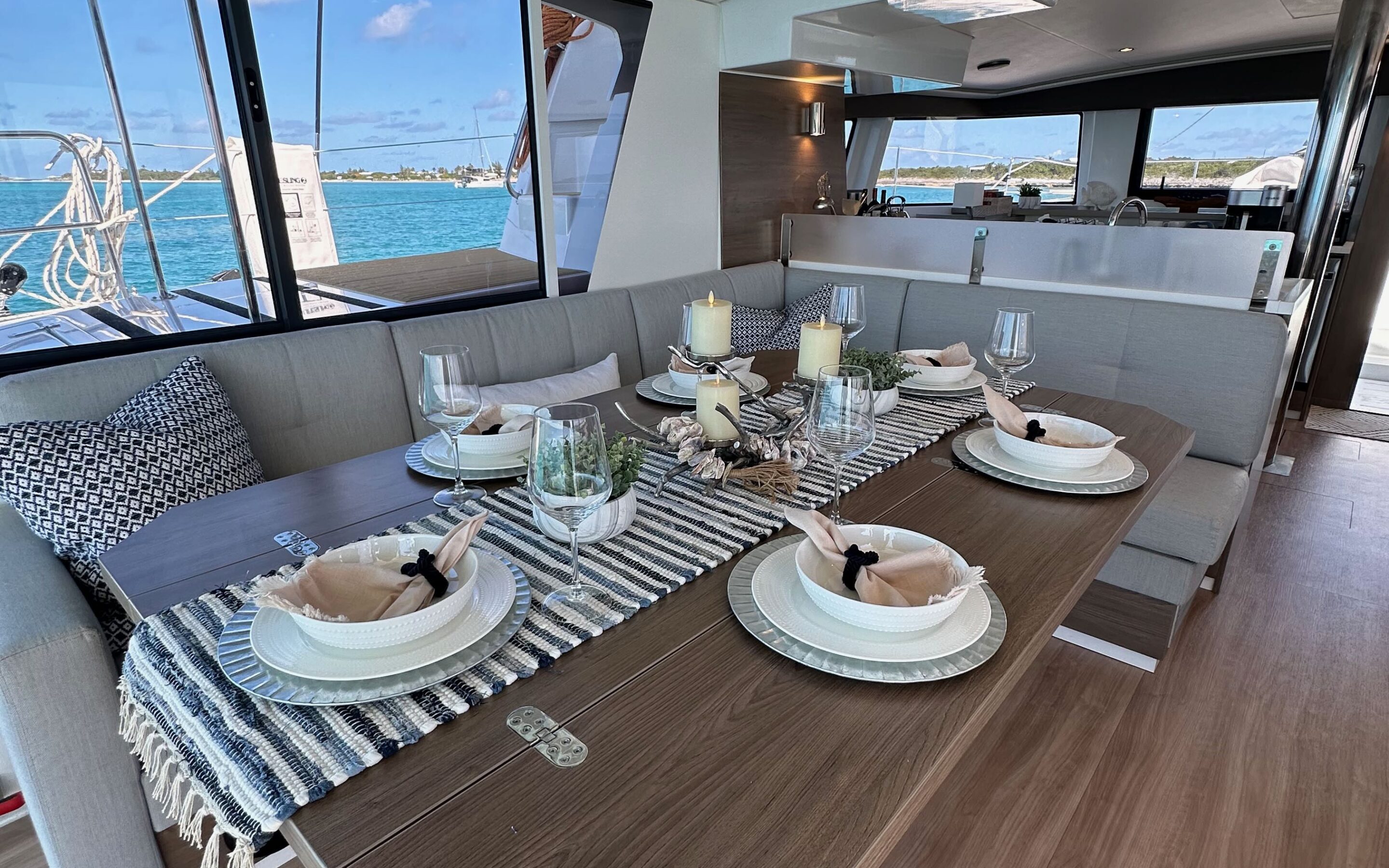 Interior view of a boat featuring a dining table surrounded by chairs, showcasing a cozy and inviting atmosphere.