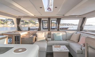 Interior view of a boat featuring a cozy couch and a well-equipped kitchen area.