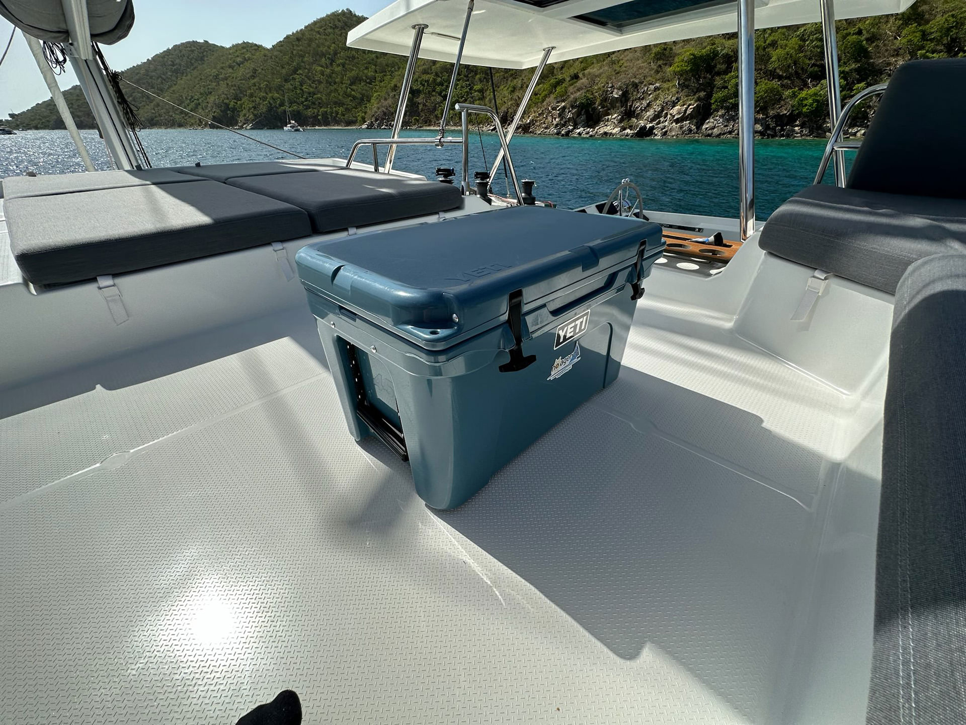 A cooler positioned on the back of a boat, surrounded by the vast expanse of the ocean.