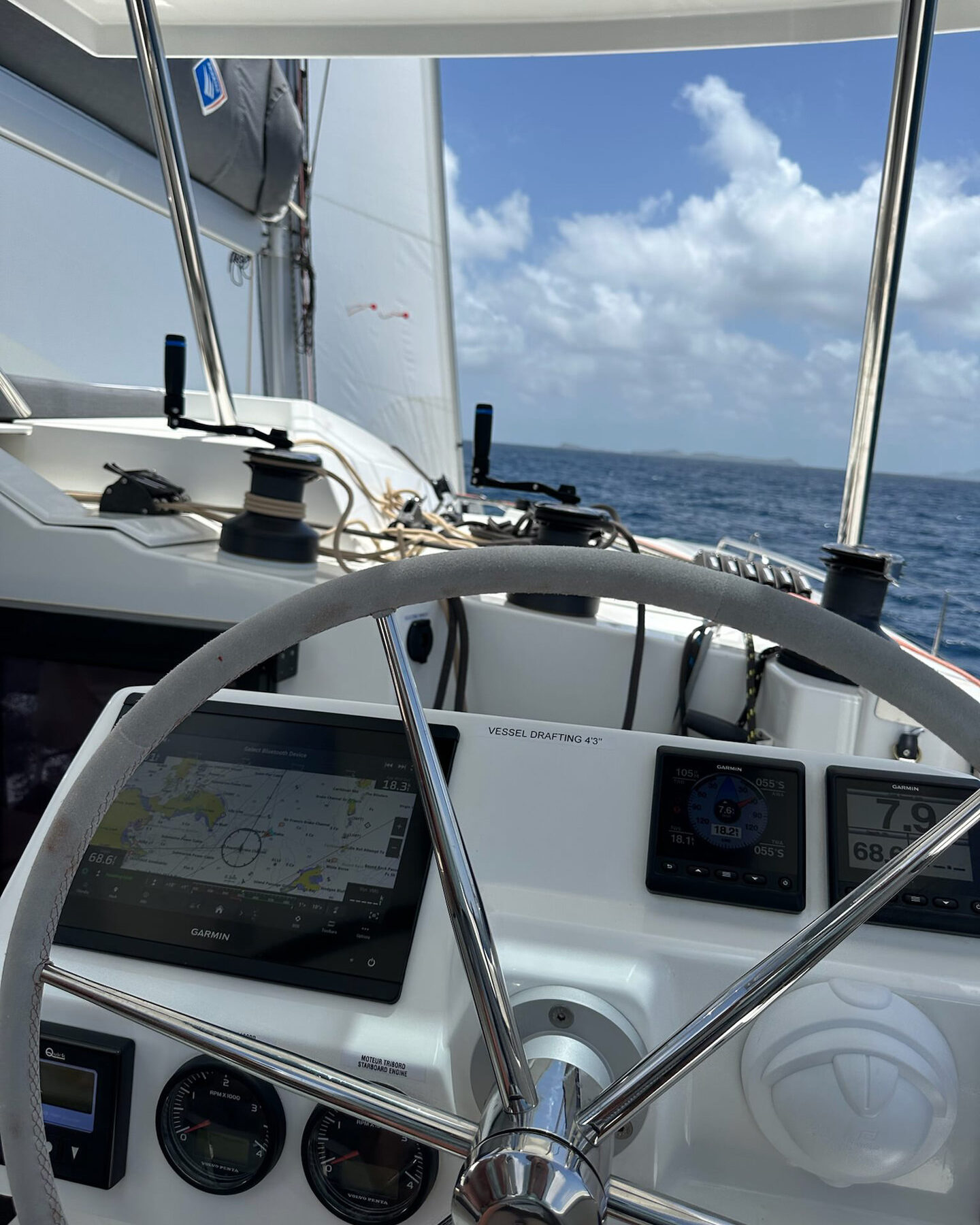 A close-up view of a white steering wheel, showcasing its sleek design and smooth surface.