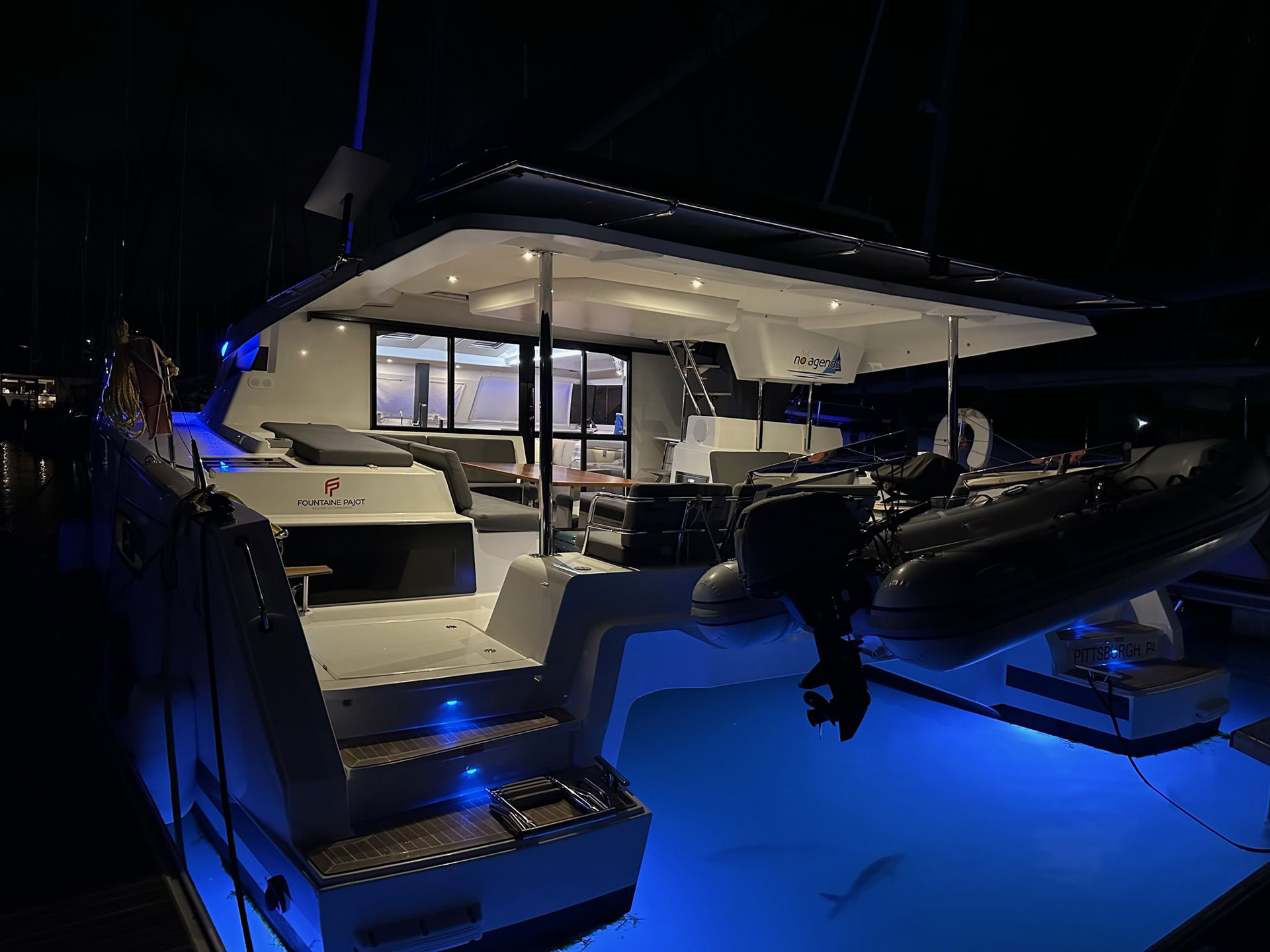 A boat illuminated by blue lights on the deck, creating a serene and captivating nighttime atmosphere.