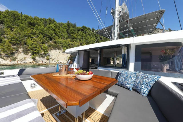 A spacious living area on a catamaran, seamlessly blending indoor comfort with stunning views of the surrounding water.