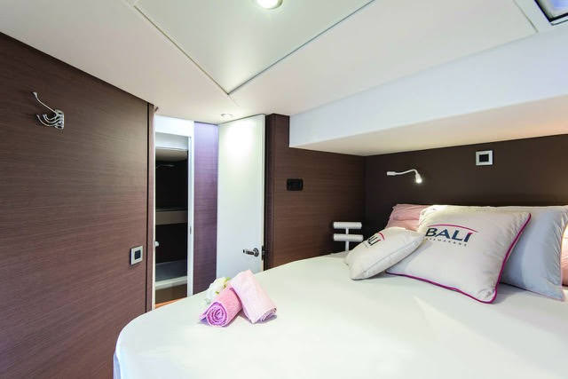 A cozy bedroom featuring a neatly made bed and a stylish mirror reflecting the room's ambiance.