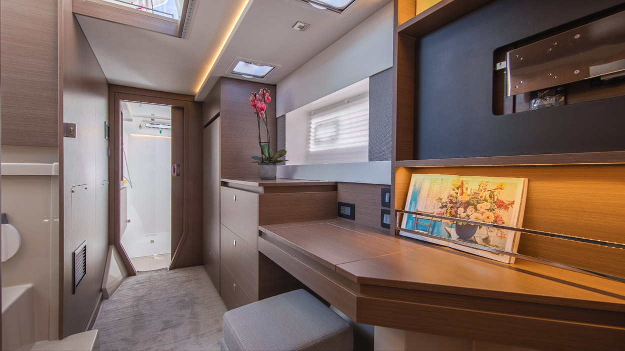 Serenity – Interior 02 A luxurious yacht interior featuring a stylish desk and a comfortable bed, showcasing elegance and sophistication.