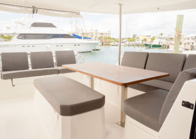 Interior view of a boat featuring a table surrounded by chairs, showcasing a cozy and functional space for dining.