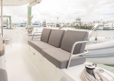 Interior view of a boat featuring a comfortable couch and a table, showcasing a cozy and inviting atmosphere.
