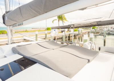 A catamaran cockpit featuring a sunbed, showcasing a serene nautical environment with seating and controls.