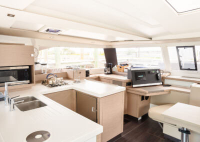 A boat's interior displaying a well-equipped kitchen and inviting dining area, designed for comfort and practicality.