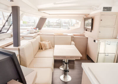 Interior view of a boat featuring a comfortable couch and a table, showcasing a cozy and inviting atmosphere.
