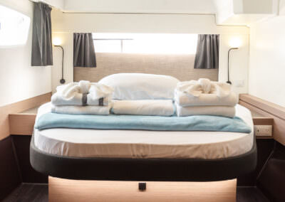 A compact room showcasing a bed positioned next to a window, enhancing the space's warmth and comfort.