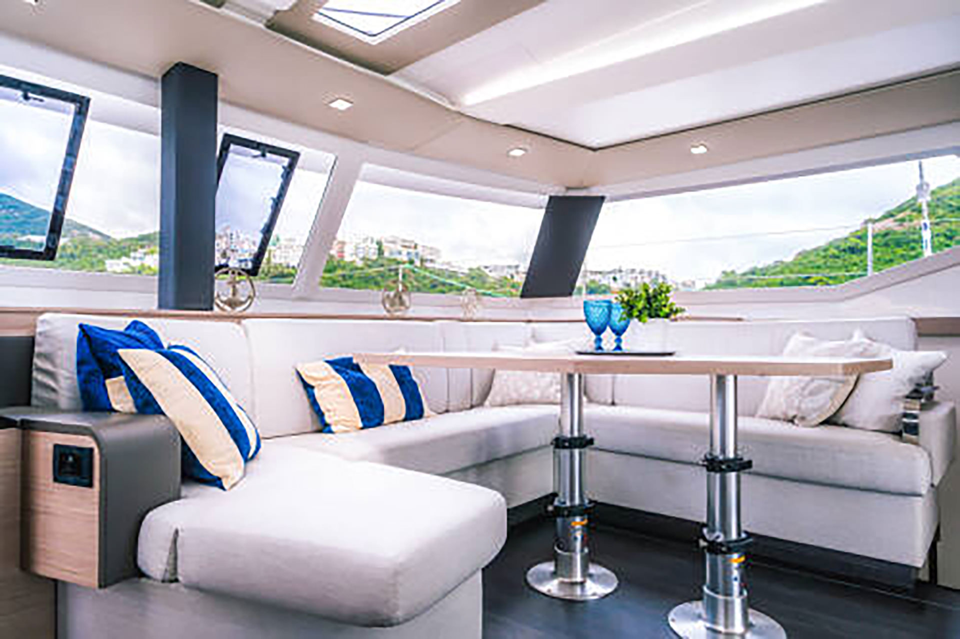 Interior view of a boat featuring a comfortable couch and a table, showcasing a cozy and inviting atmosphere.