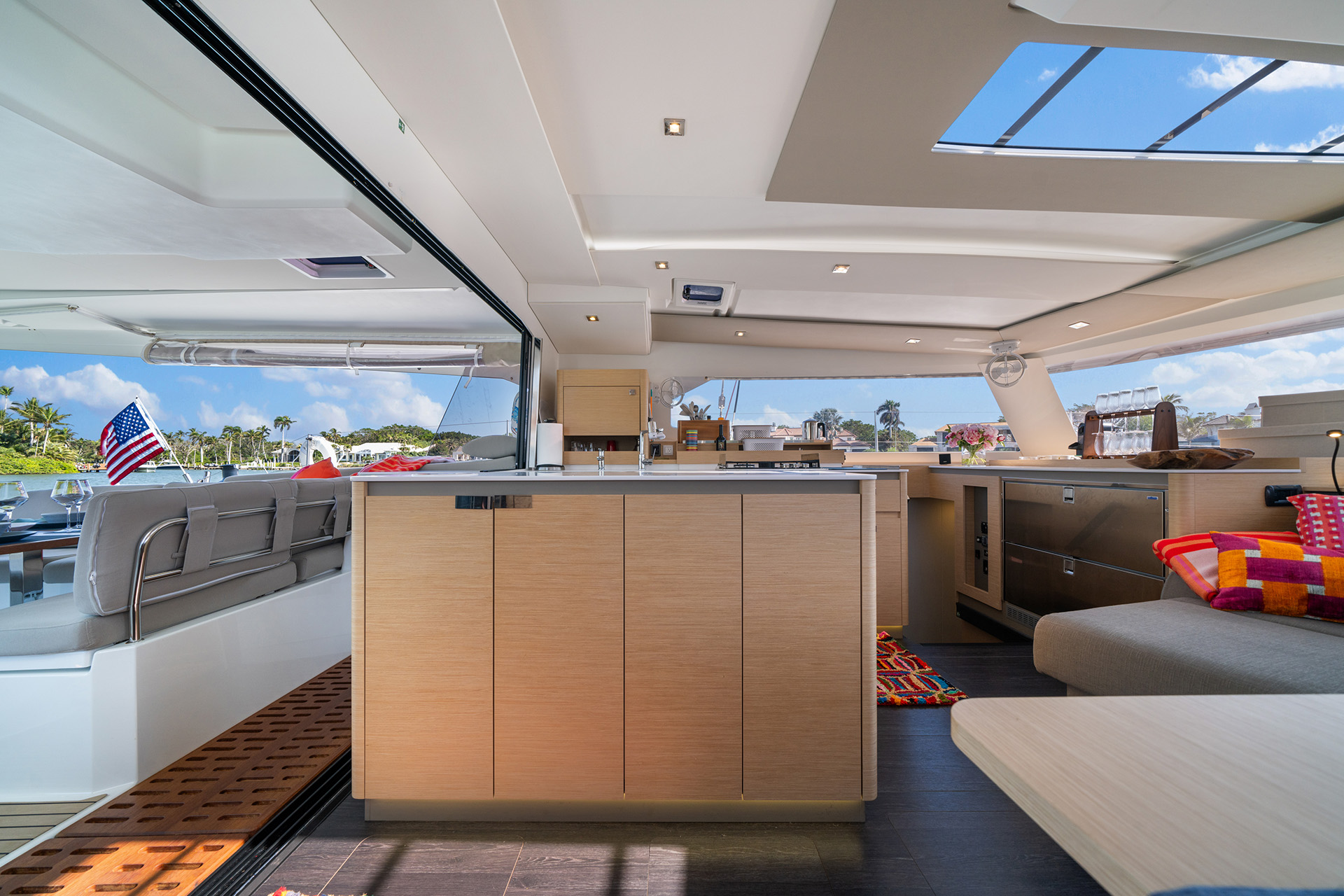Interior view of a boat featuring a cozy kitchen and living room area, showcasing nautical decor and comfortable furnishings.
