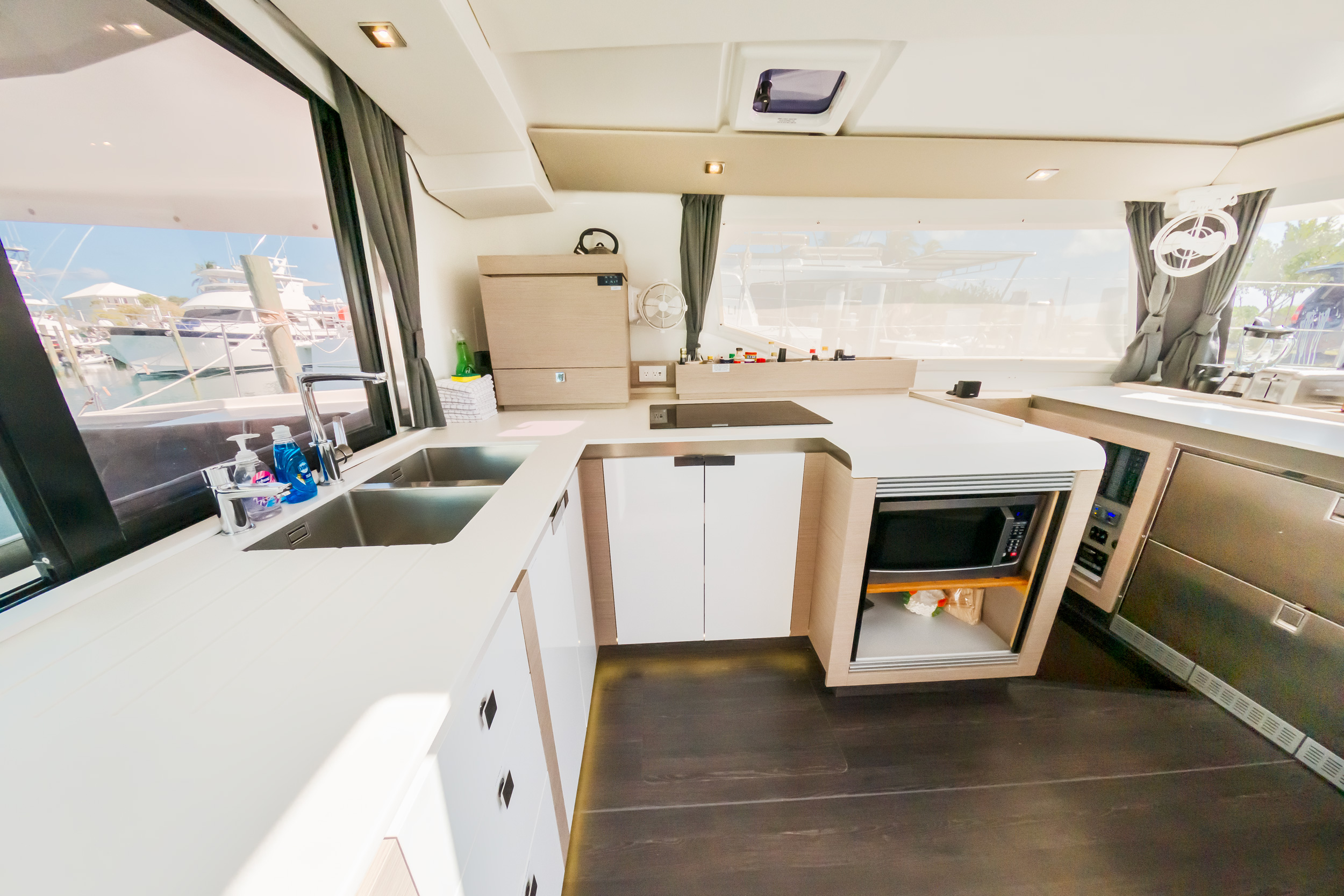 A cozy kitchen and living area on a boat, featuring modern appliances and comfortable seating with nautical decor.