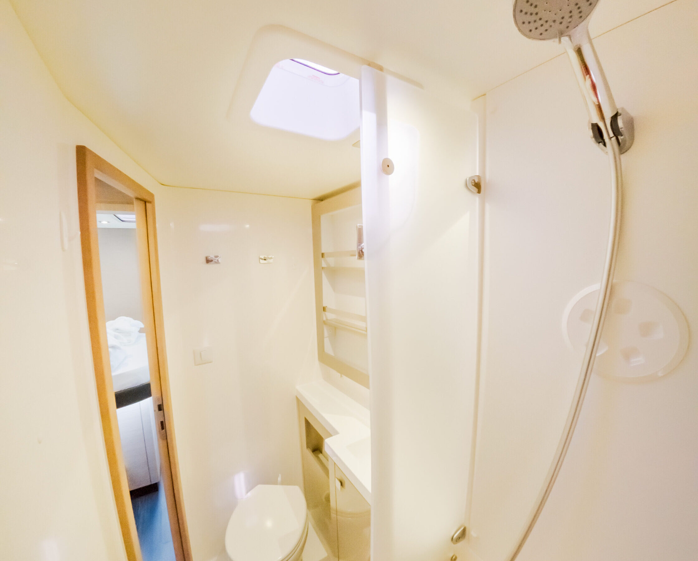 A clean bathroom featuring a shower and a toilet, with neutral-colored tiles and modern fixtures.