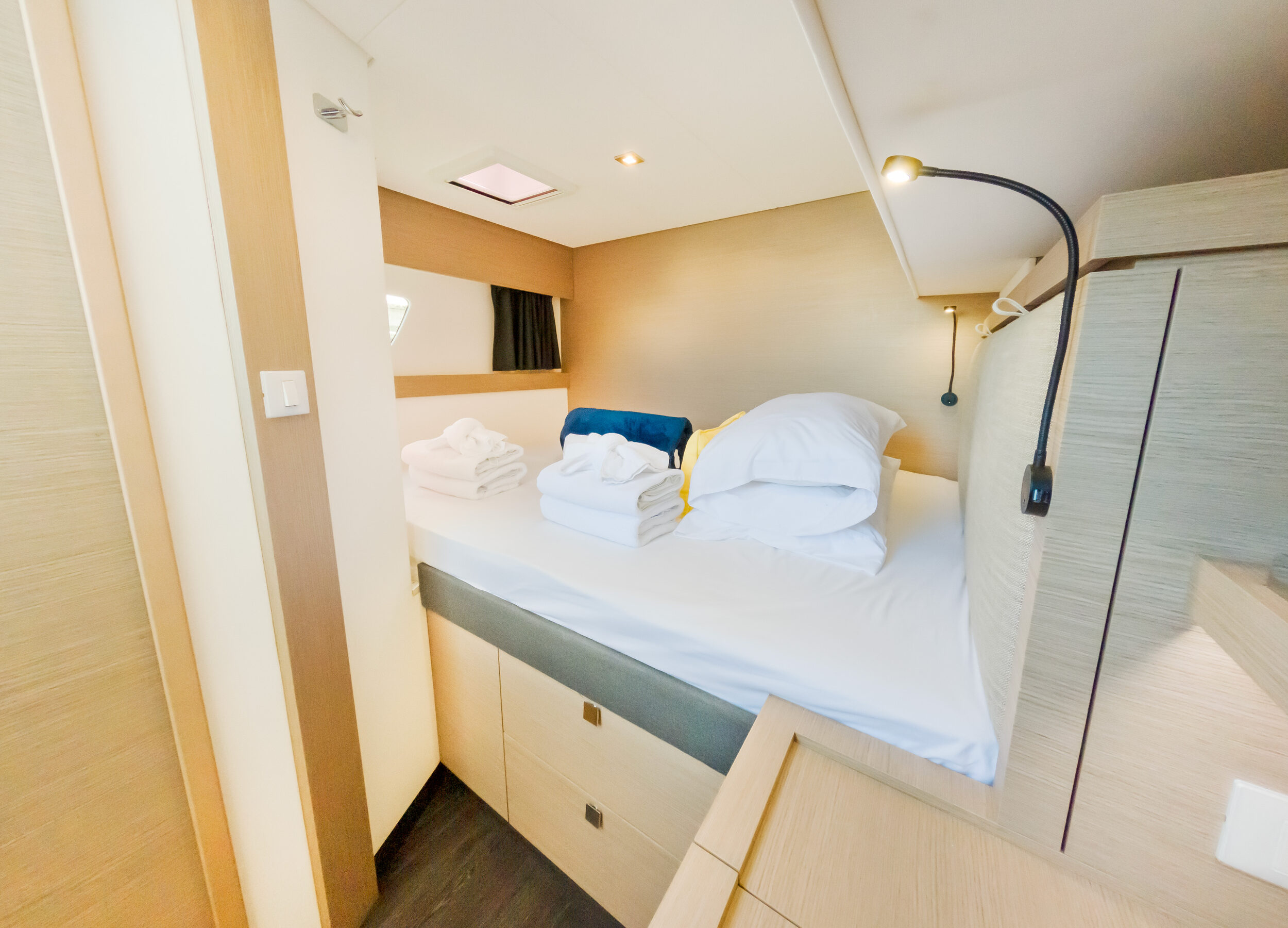 Interior of a boat featuring a bed and a desk, showcasing a cozy and functional living space.