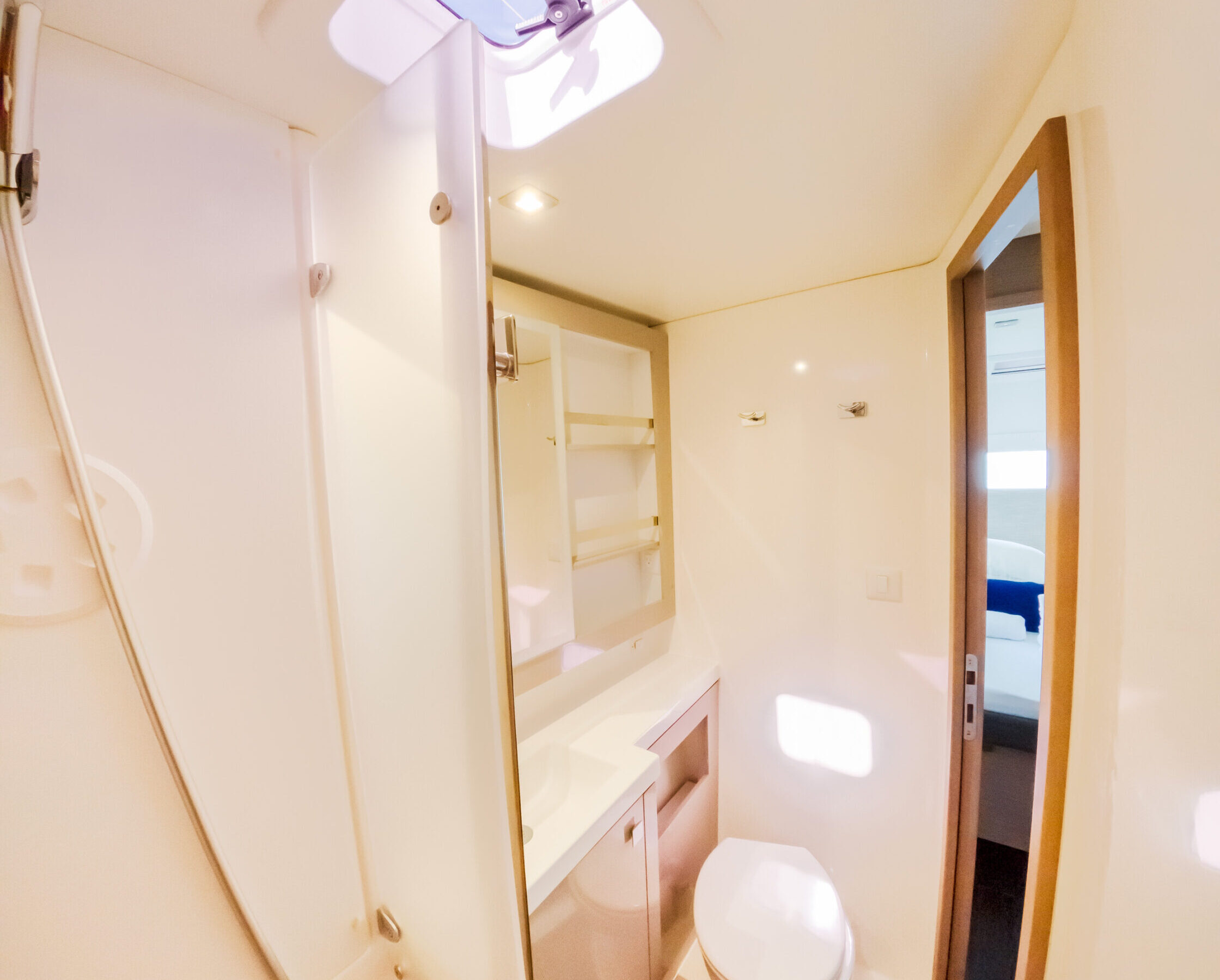 A bathroom featuring a toilet, shower, and sink, designed for functional and efficient use of space.