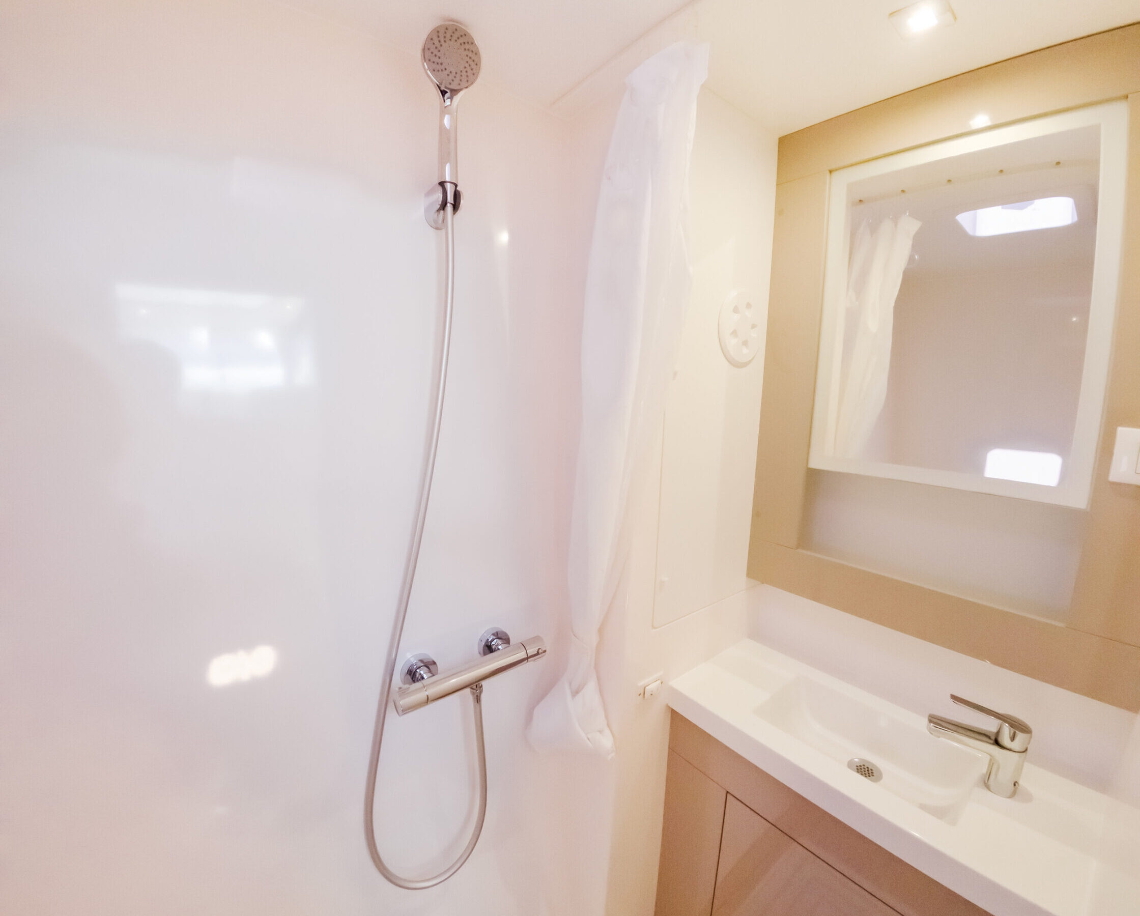 A bathroom featuring a shower and a sink, with modern fixtures and neutral-colored walls.