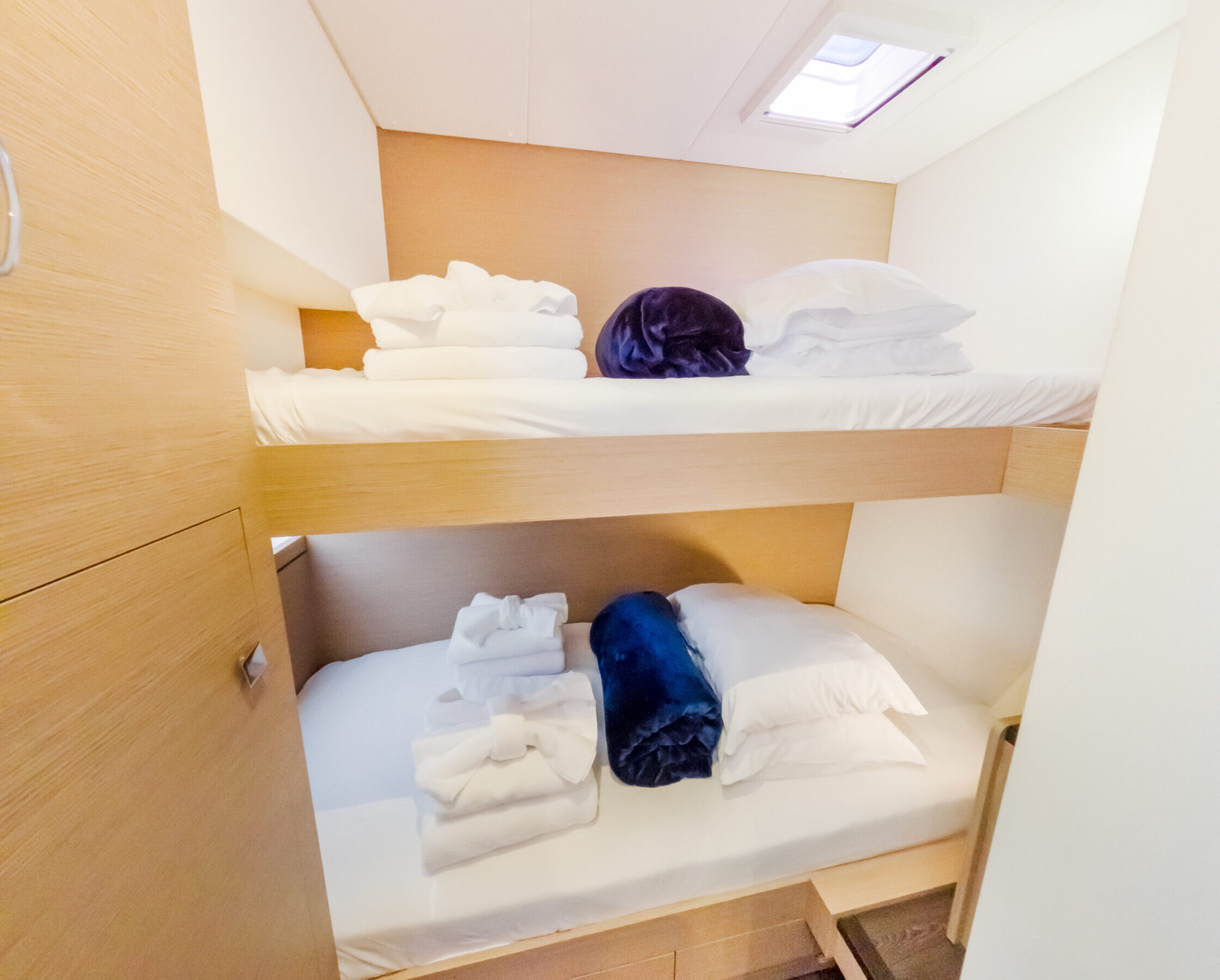 A wooden bunk bed with two stacked beds and a small closet beside it, designed for space-saving in a bedroom.