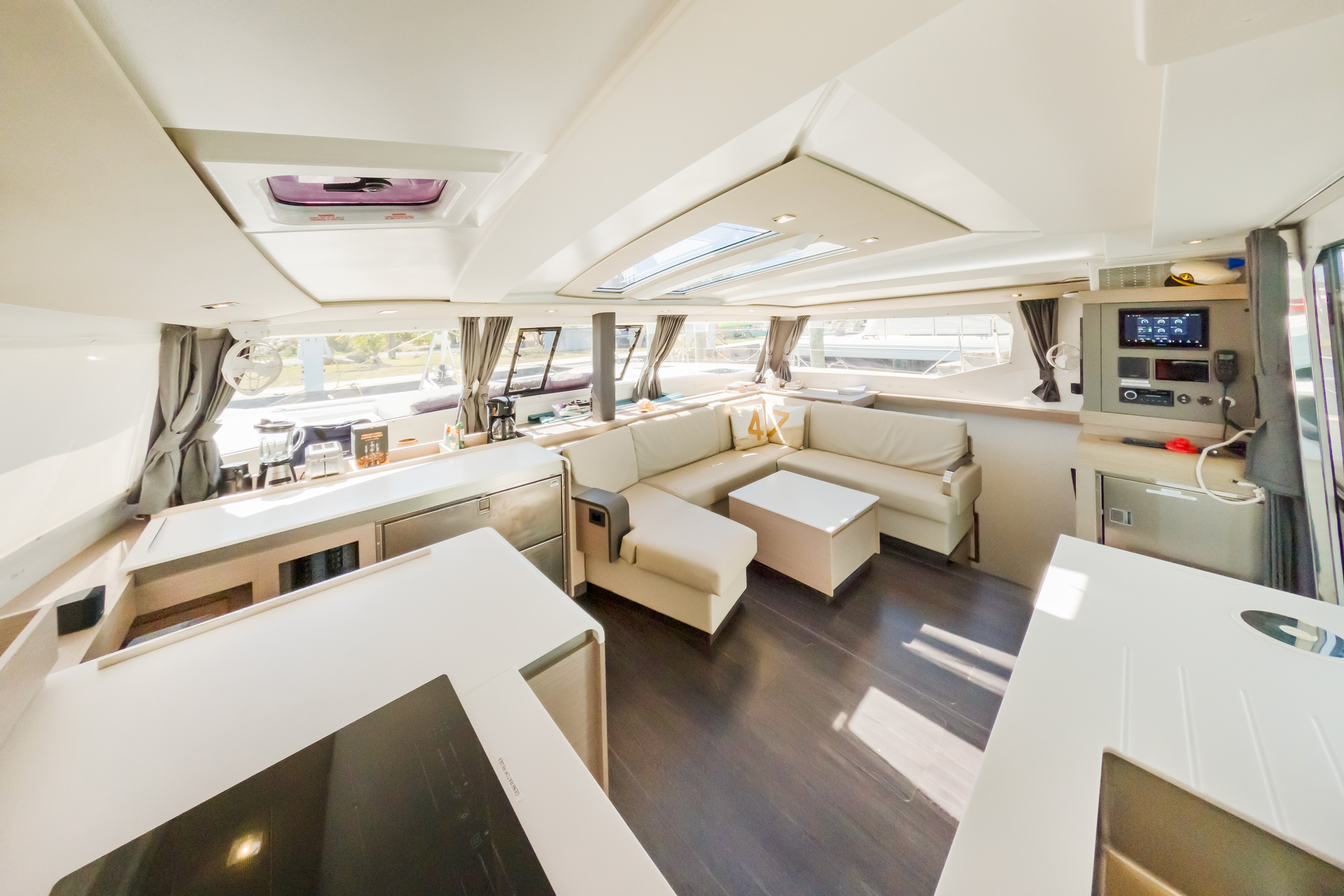 Interior view of a boat featuring a kitchen and living area, showcasing cozy furnishings and nautical decor.