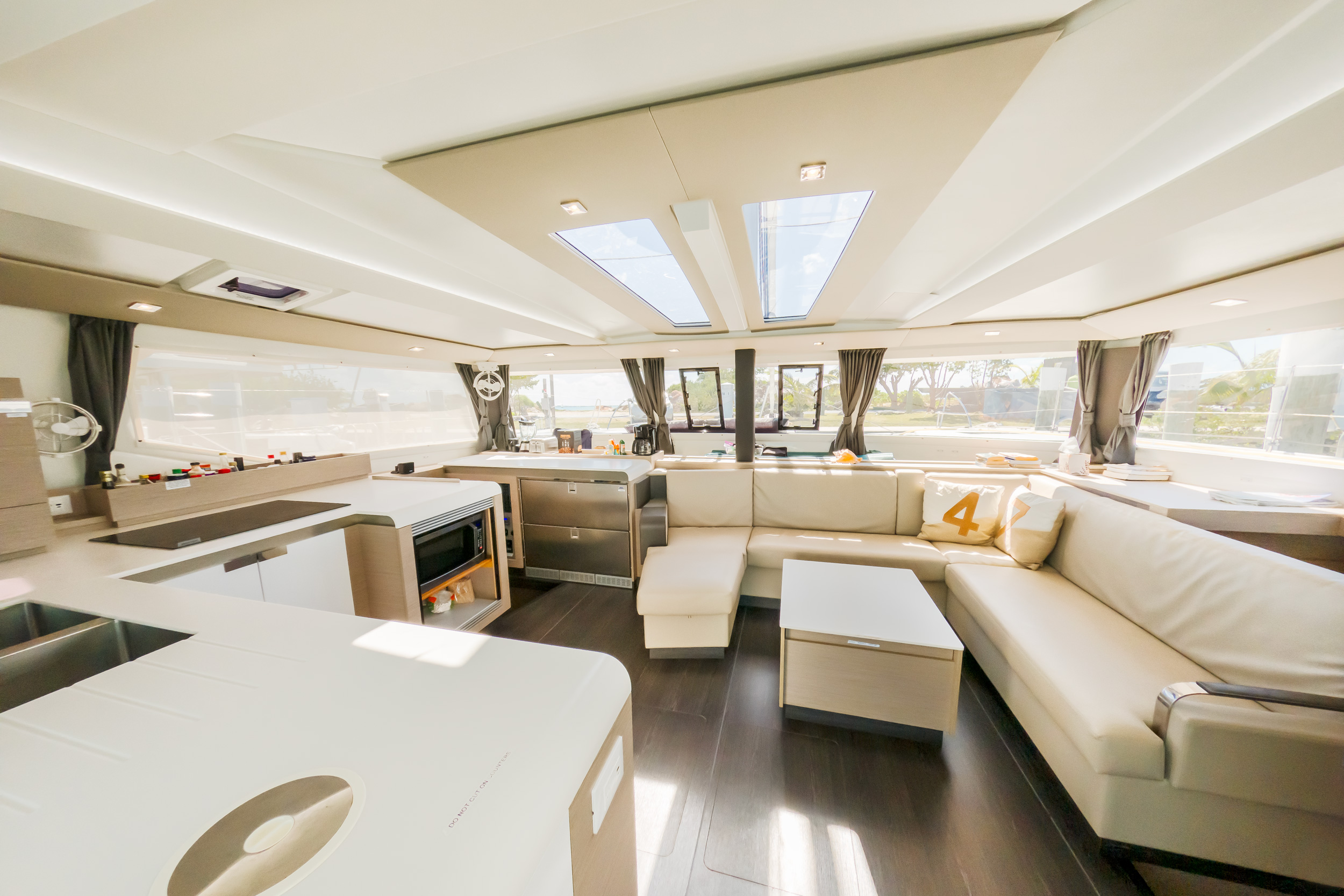 A cozy living room featuring a couch, with an open view into a modern kitchen area.