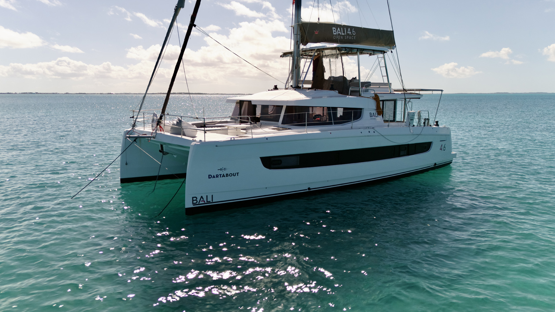 A catamaran anchored peacefully in the ocean, surrounded by calm waters and a clear blue sky.