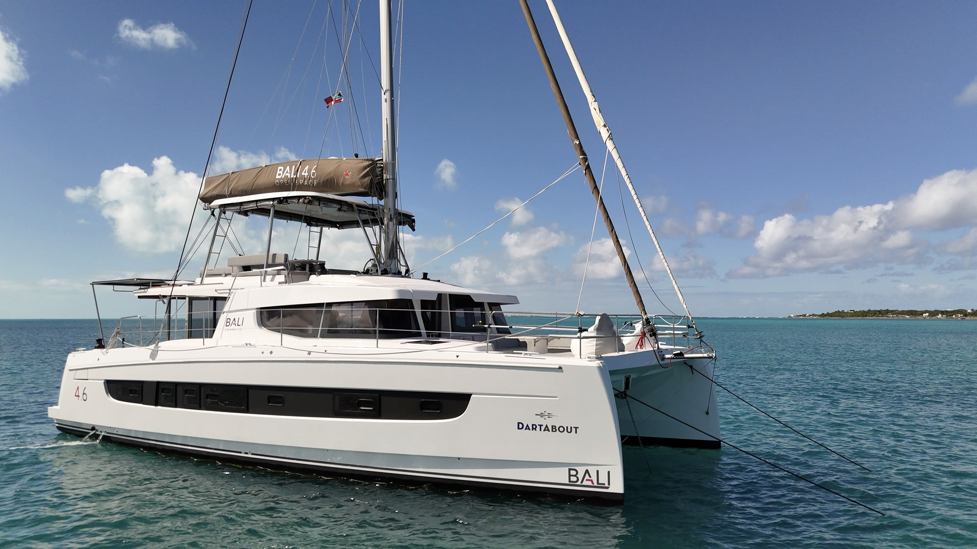 A catamaran anchored peacefully in the ocean, surrounded by calm waters and a clear blue sky.