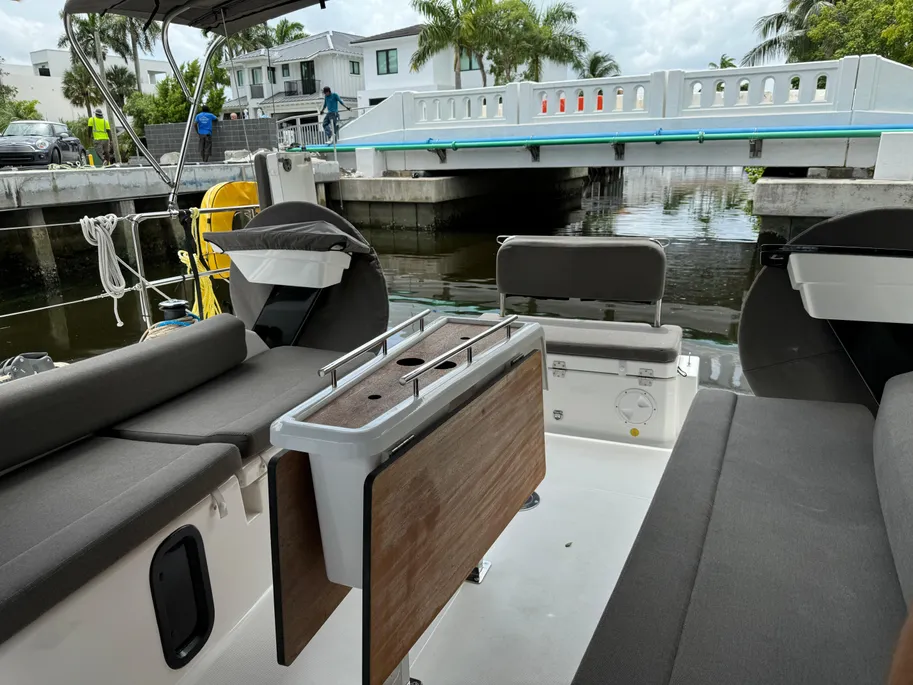 Interior view of a boat featuring a large control console and seating area, showcasing nautical design elements.