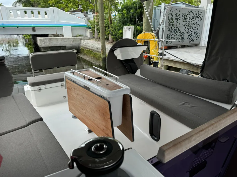 Interior of a boat featuring a table surrounded by chairs, showcasing a cozy dining area on the water.