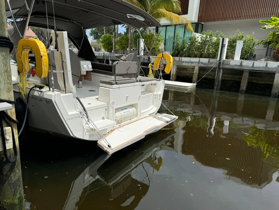A boat is docked at a pier, with another dock visible nearby.