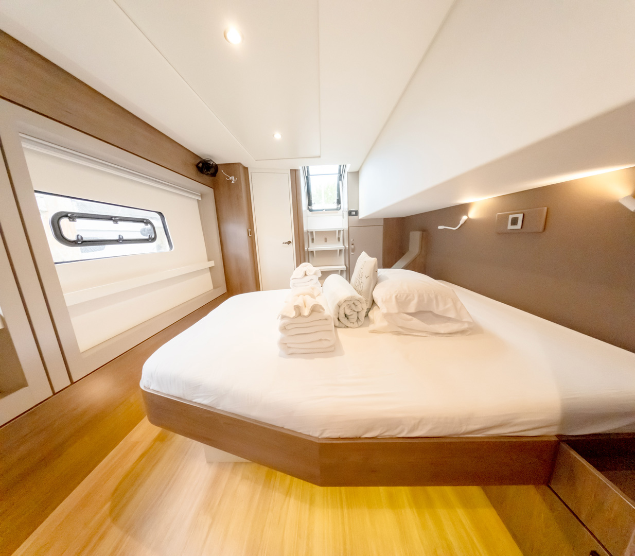 Interior of a boat featuring a bed and a desk, showcasing a cozy and functional living space.