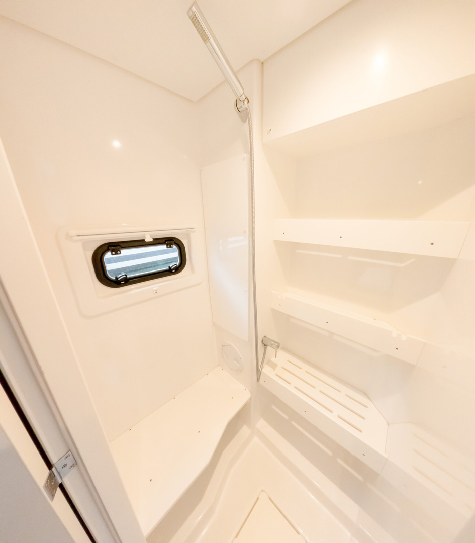Interior view of a bathroom featuring a shower and a sink, with neutral-colored tiles and modern fixtures.